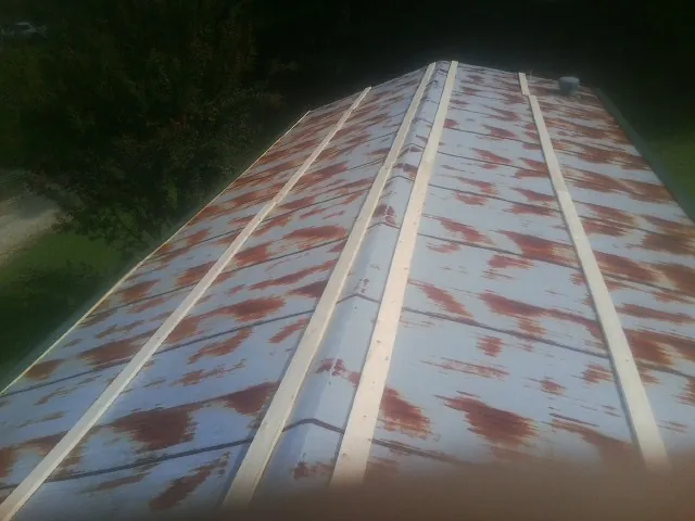 Rusted metal roof panels with new wood purlins before replacement — Storm Damage Roof Repair in Kensett by Roofing Brothers