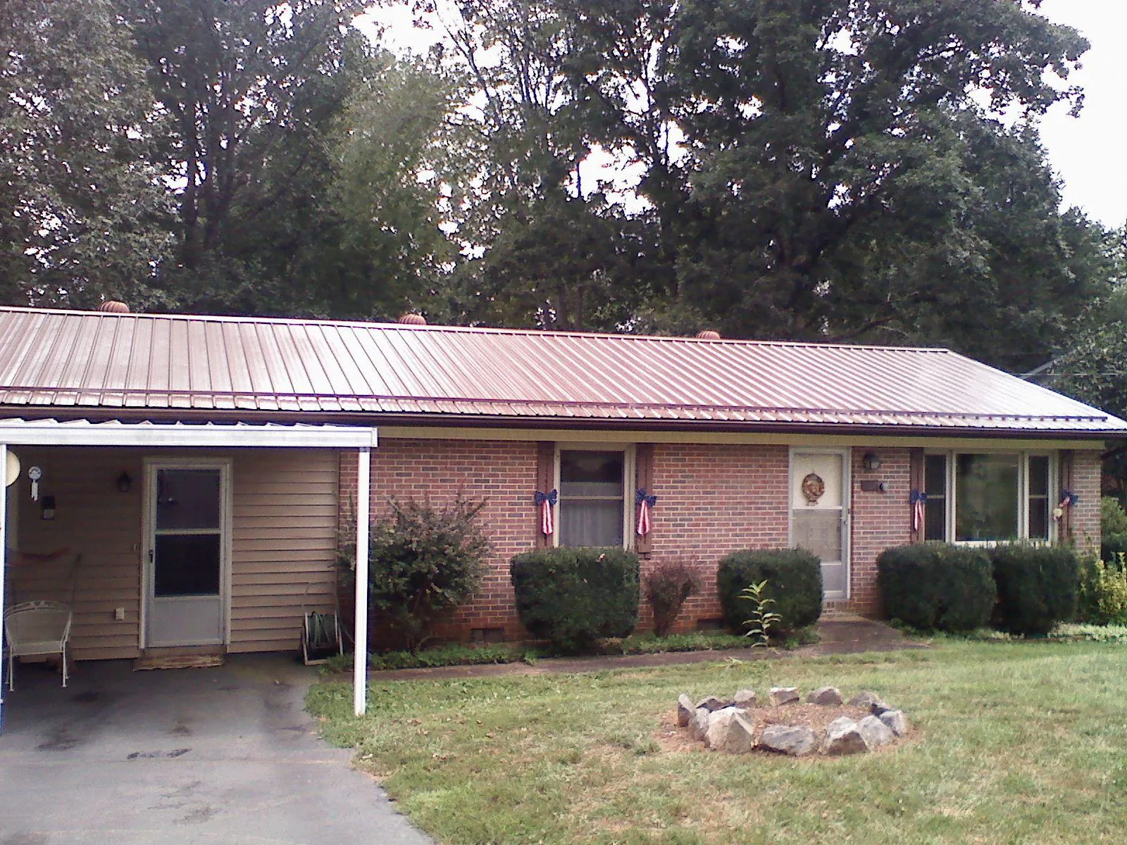 Bronze metal roof and carport on a brick ranch home — Roof Repair work by our crew in Kensett